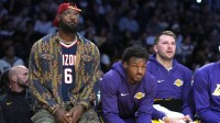 Los Angeles Lakers forward LeBron James (left), guard Bronny James (center) and guard Luka Doncic watch from the bench in the first half against the Minnesota Timberwolves at Crypto.com Arena.