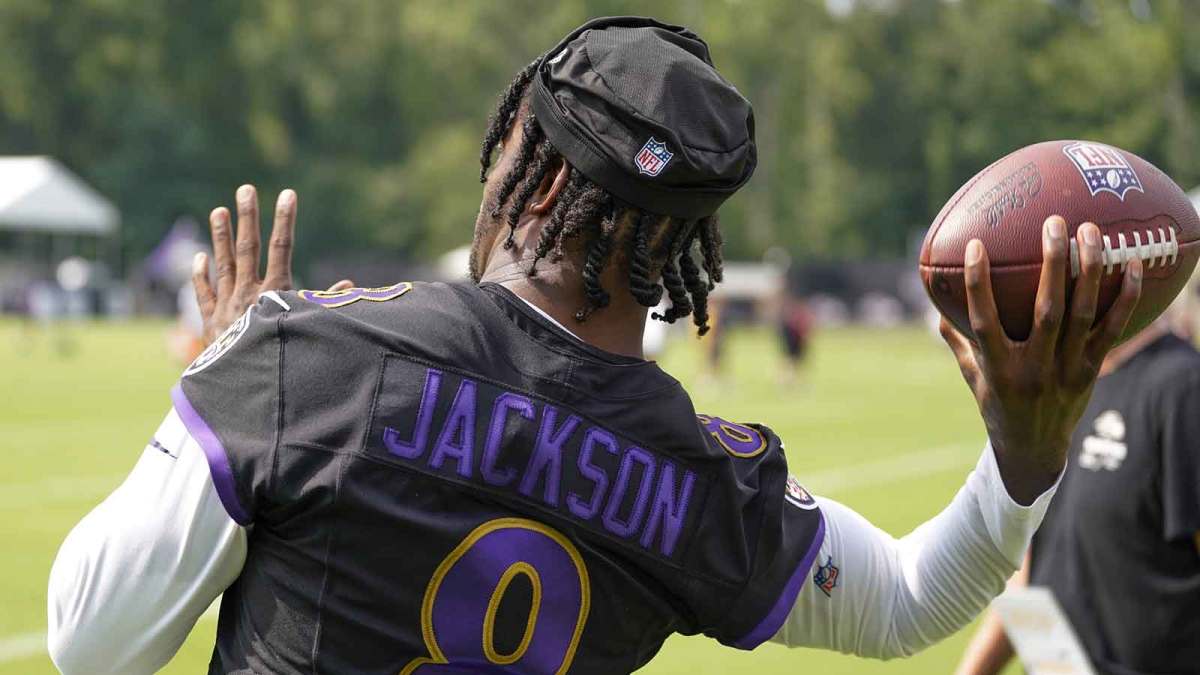 Baltimore Ravens quarterback Lamar Jackson (8) throws a pass to a fan after training camp practice at Under Armour Performance Center.