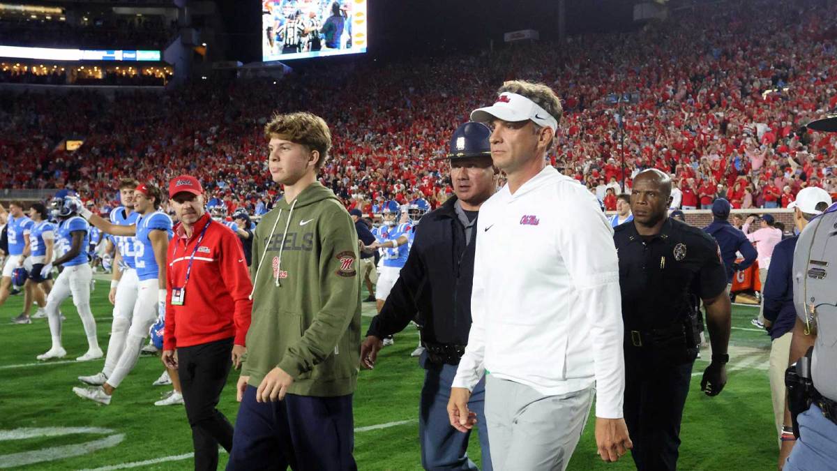 Mississippi Rebels head coach Lane Kiffin and his son, Knox Kiffin, walk onto the field after defeating the Florida Gators at Vaught-Hemingway Stadium.