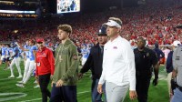 Mississippi Rebels head coach Lane Kiffin and his son, Knox Kiffin, walk onto the field after defeating the Florida Gators at Vaught-Hemingway Stadium.