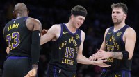 Los Angeles Lakers guard Austin Reaves (15) is congratulated by forward LeBron James (23) and guard Luka Doncic (77) after a three-point basket in the second quarter at Crypto.com Arena.