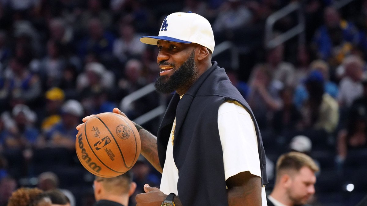 Los Angeles Lakers forward LeBron James (23), wearing a Los Angeles Dodgers hat, watches from the sideline during a break against the Golden State Warriors in the third quarter at Chase Center.