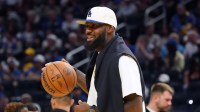 Los Angeles Lakers forward LeBron James (23), wearing a Los Angeles Dodgers hat, watches from the sideline during a break against the Golden State Warriors in the third quarter at Chase Center.