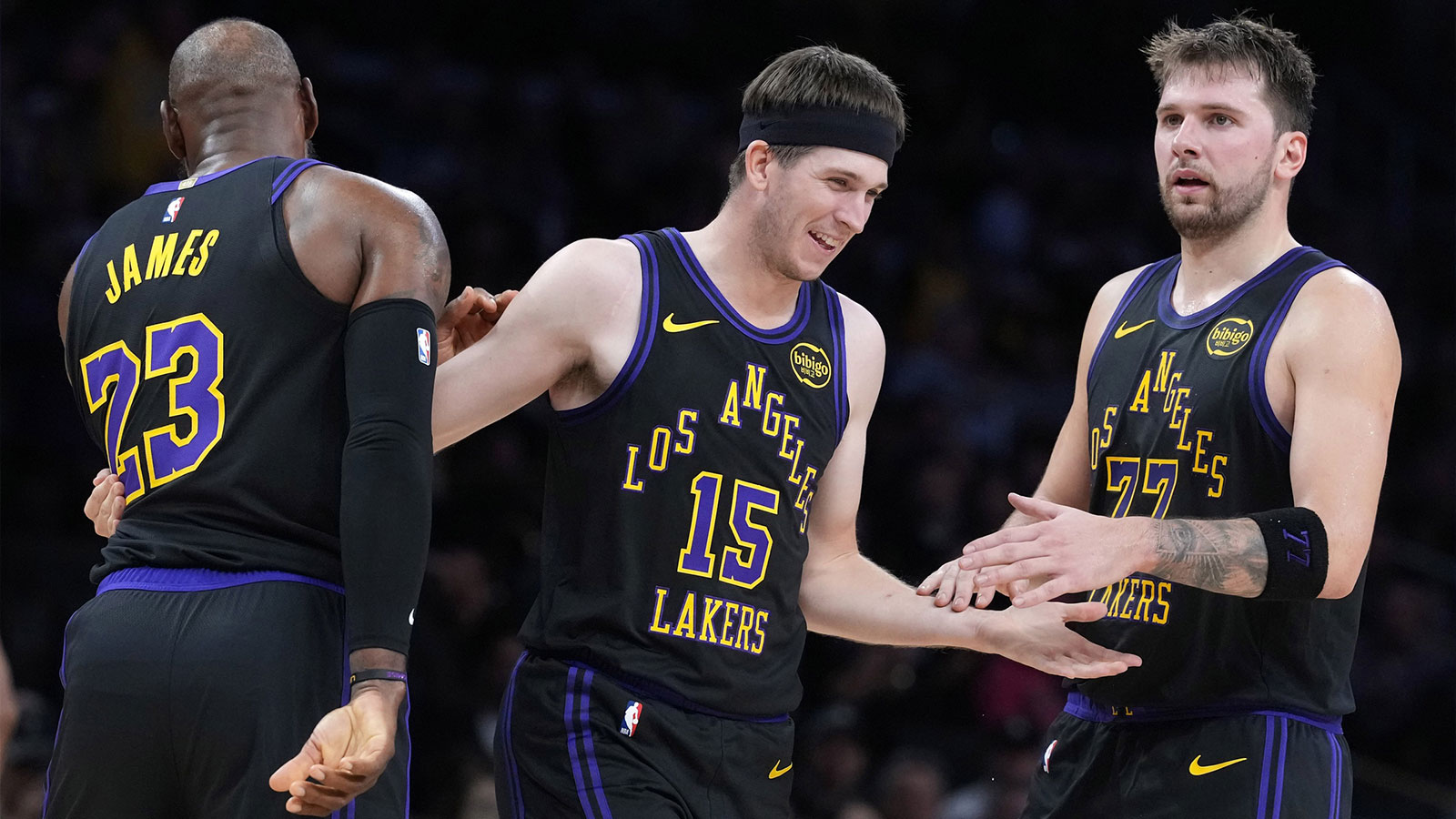 Los Angeles Lakers guard Austin Reaves (15) is congratulated by forward LeBron James (23) and guard Luka Doncic (77) after a three-point basket in the second quarter at Crypto.com Arena.