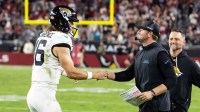 Jacksonville Jaguars quarterback Trevor Lawrence (16) celebrates with head coach Liam Coen after defeating the Arizona Cardinals at State Farm Stadium.