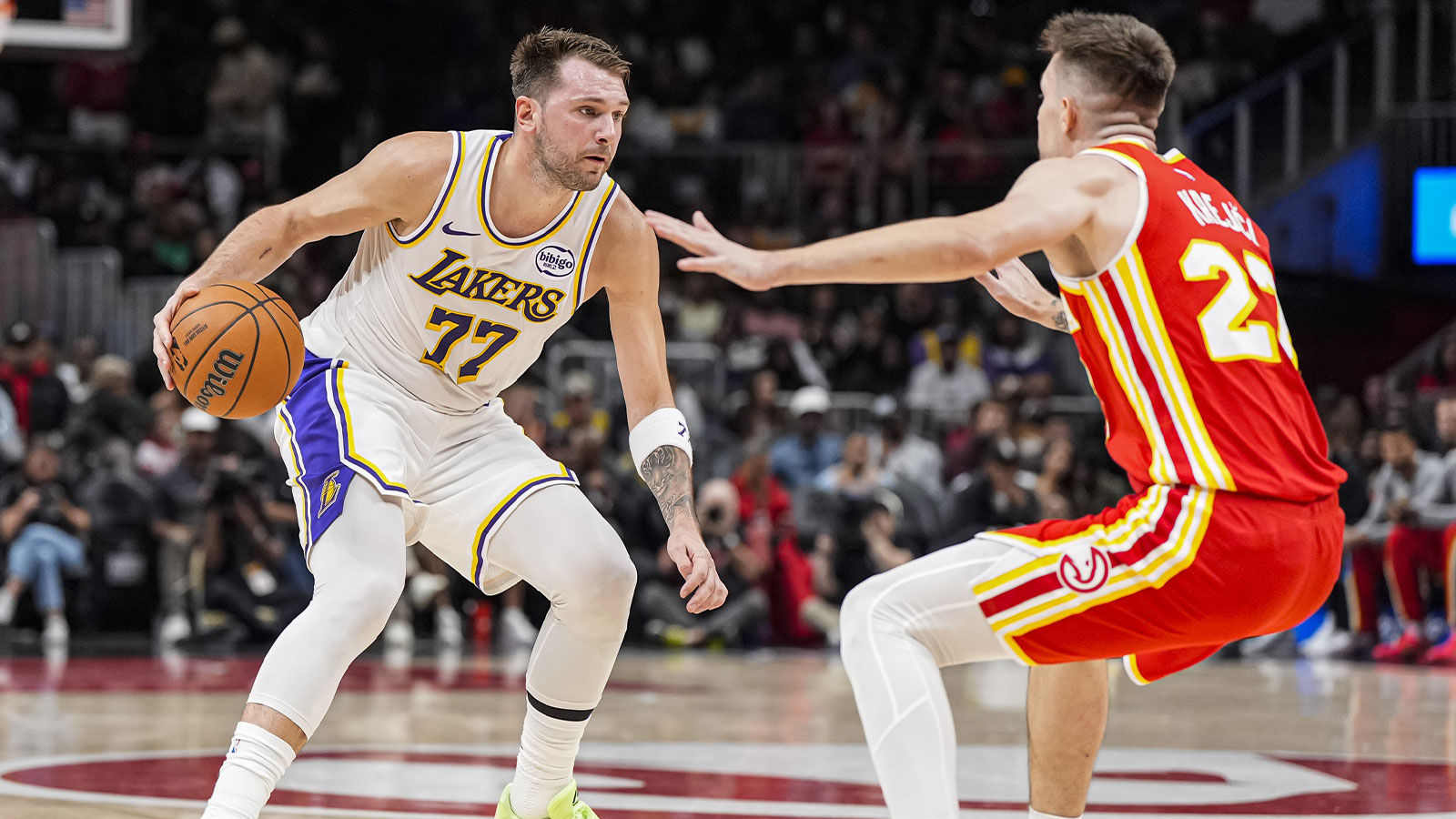 Los Angeles Lakers guard Luka Doncic (77) dribbles guarded by Atlanta Hawks guard Vit Krejci (27) during the first half at State Farm Arena.