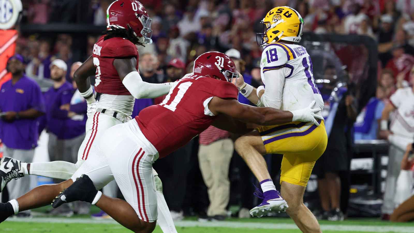  Louisiana State Tigers quarterback Garrett Nussmeier (18) under pressure from Alabama Crimson Tide linebacker Deontae Lawson (0) and defensive lineman Keon Keeley (31) during the second quarter of the game at Saban Field at Bryant-Denny Stadium. 