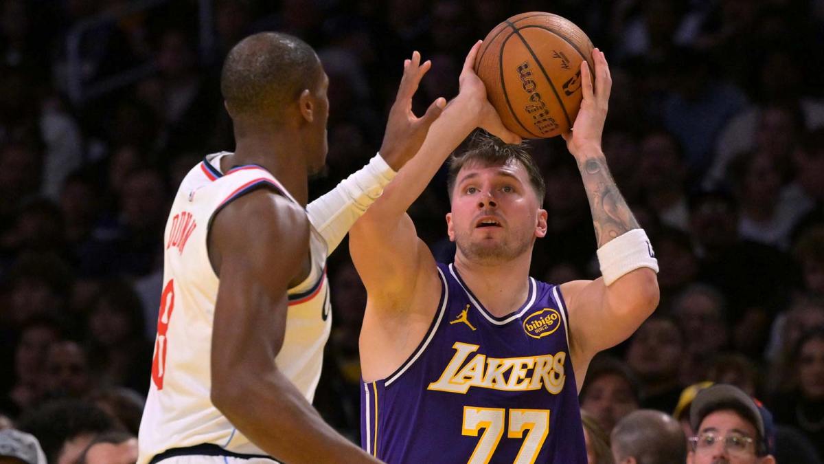 Nov 25, 2025; Los Angeles, California, USA; Los Angeles Lakers guard Luka Doncic (77) is defended by Los Angeles Clippers guard Kris Dunn (8) during the first half at Crypto.com Arena. Mandatory Credit: Jayne Kamin-Oncea-Imagn Images