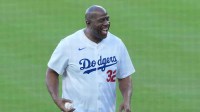 Los Angeles Dodgers co owner Magic Johnson reacts before throwing the ceremonial first pitch before game five of the 2025 MLB World Series between the Toronto Blue Jays and the Los Angeles Dodgers at Dodger Stadium.