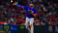 Texas Rangers second baseman Marcus Semien (2) throws to first for the out against Los Angeles Angels center fielder Jo Adell (7) ;d at Angel Stadium