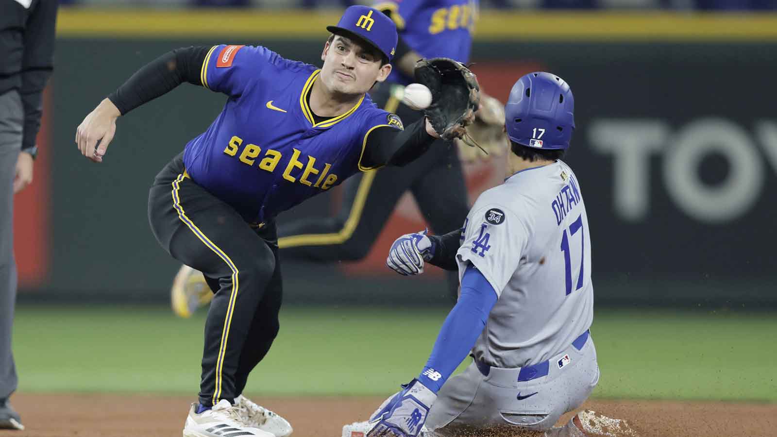 Los Angeles Dodgers designated hitter Shohei Ohtani (17) steals second as Seattle Mariners second baseman Cole Young (2) reaches for the throw during the third inning at T-Mobile Park.