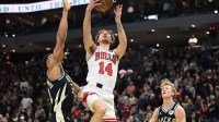 Nov 7, 2025; Milwaukee, Wisconsin, USA; Chicago Bulls forward Matas Buzelis (14) takes a shot between Milwaukee Bucks forward Giannis Antetokounmpo (34) and guard AJ Green (20) in the first quarter at Fiserv Forum. Mandatory Credit: Benny Sieu-Imagn Images