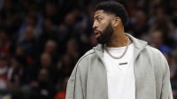 Mavericks forward Anthony Davis looks on from the bench during a timeout against the Washington Wizards in the second half at Capital One Arena with Mark Cuban in the background