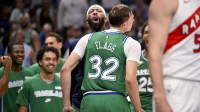 Mavericks forward Cooper Flagg (32) and forward Anthony Davis (3) celebrates after Flagg dunks the ball against the Toronto Raptors during the third quarter at the American Airlines Center with Mavericks veteran Klay Thompson in the background