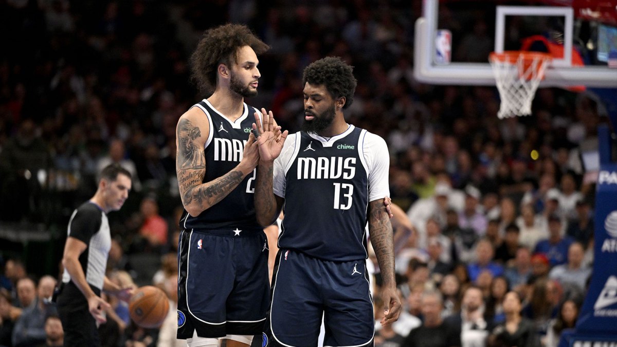 Mavericks forward Naji Marshall (13) is retrained by center Dereck Lively II (2) after Marshall receives a technical foul during the second half against the New Orleans Pelicans at the American Airlines Center with the Grizzlies logo in the background