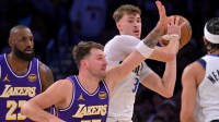 Mavericks forward Cooper Flagg (32) is defended by Los Angeles Lakers guard Luka Doncic (77) in the first half at Crypto.com Arena