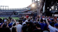 Fans watch and listen as Beatles tribute band 1964 the Tribute performs before a game between the New York Mets and Seattle Mariners at Citi Field.