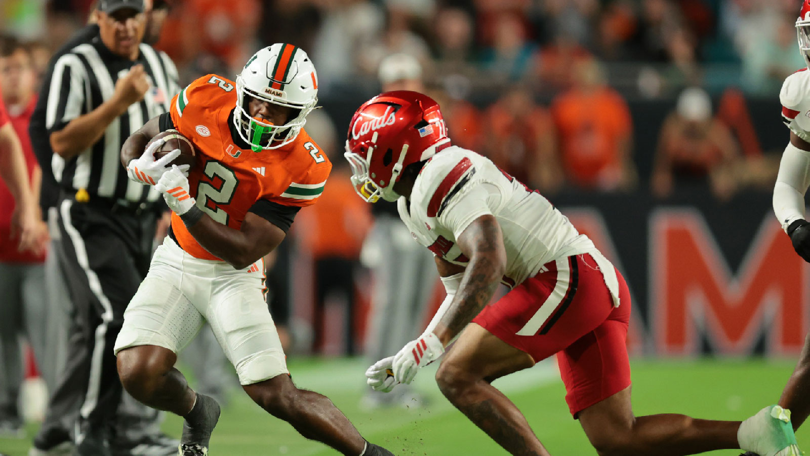 Miami Hurricanes running back Jordan Lyle (2) runs out of bounds as Louisville Cardinals defensive back Jojo Evans Jr. (27) defends during the fourth quarter at Hard Rock Stadium.