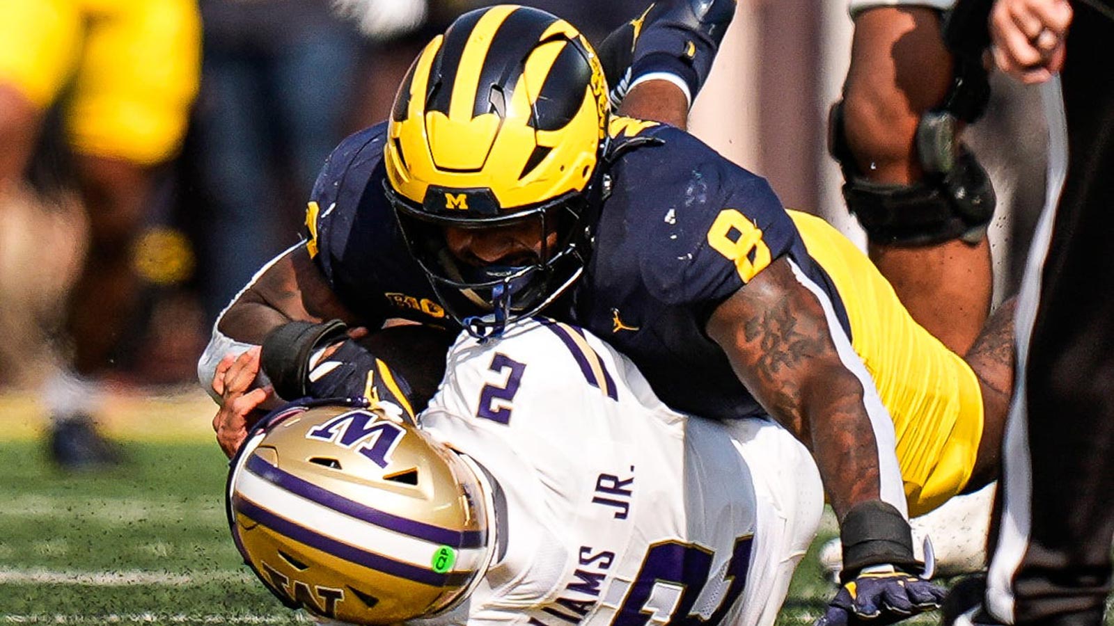 Michigan edge Derrick Moore (8) sacks Washington quarterback Demond Williams Jr. (2) during the first half at Michigan Stadium in Ann Arbor on Saturday, Oct. 18, 2025.