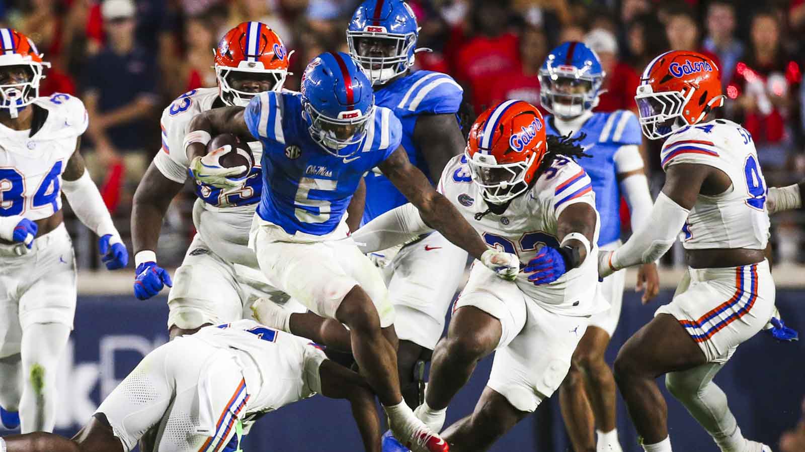 Mississippi Rebels running back Kewan Lacy (5) rushes against the Florida Gators safety Jordan Castell (14) and defensive lineman Brien Taylor Jr. (33) during the second quarter at Vaught-Hemingway Stadium.