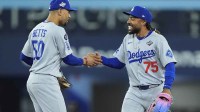Los Angeles Dodgers shortstop Mookie Betts (50) and center fielder Justin Dean (75) celebrate after defeating the Toronto Blue Jays during game six of the 2025 MLB World Series at Rogers Centre.