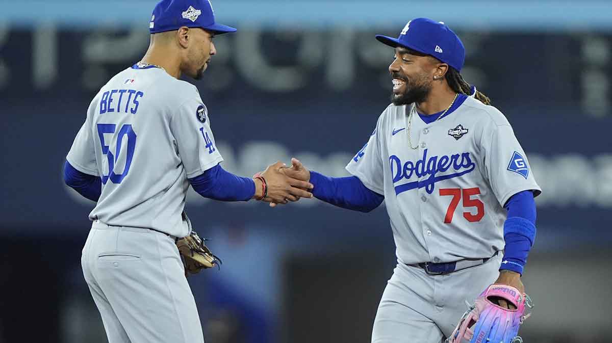 Los Angeles Dodgers shortstop Mookie Betts (50) and center fielder Justin Dean (75) celebrate after defeating the Toronto Blue Jays during game six of the 2025 MLB World Series at Rogers Centre.