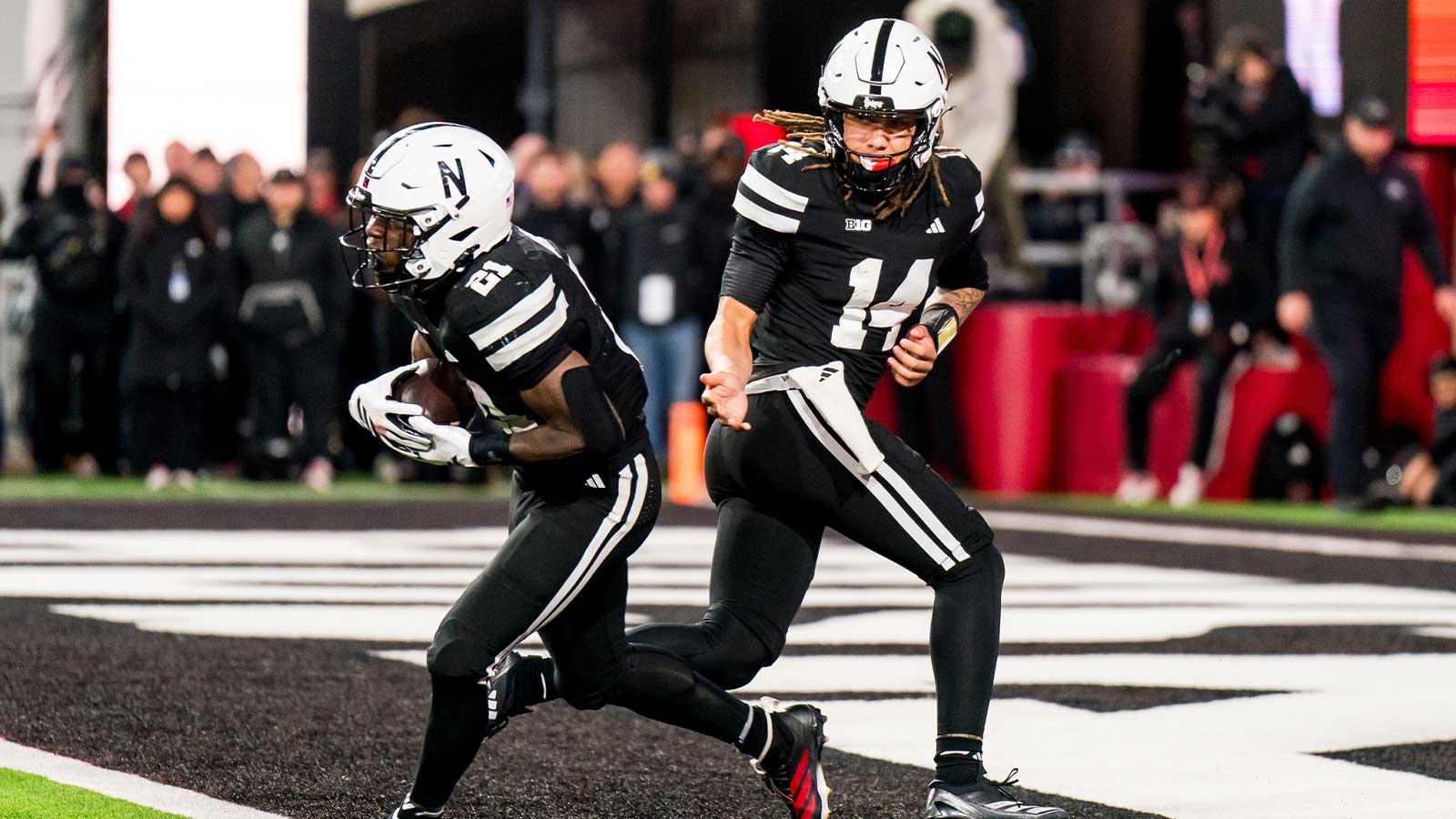 Nebraska Cornhuskers quarterback TJ Lateef (14) hands the ball off to running back Emmett Johnson (21) against the Southern California Trojans during the fourth quarter at Memorial Stadium.