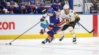 New York Islanders defenseman Matthew Schaefer (48) and Boston Bruins right wing David Pastrnak (88) battle for control of the puck in the third period at UBS Arena.
