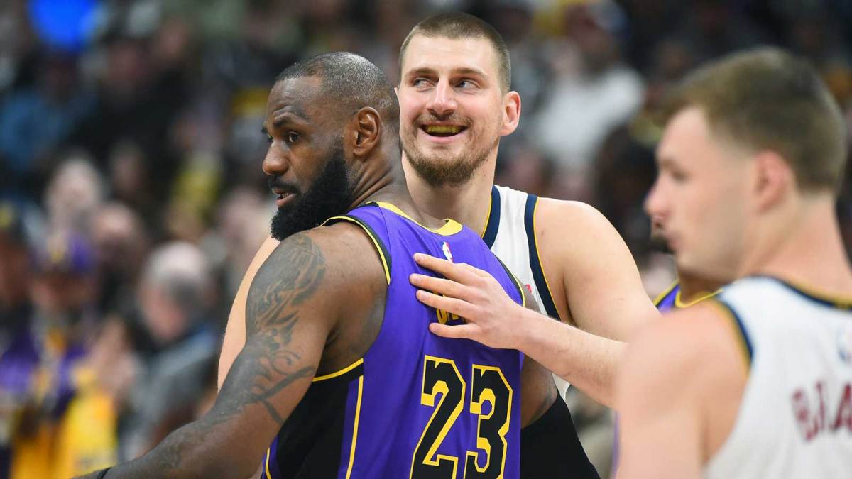 Denver Nuggets center Nikola Jokic (15) and Los Angeles Lakers forward LeBron James (23) hug before the game at Ball Arena.