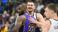 Denver Nuggets center Nikola Jokic (15) and Los Angeles Lakers forward LeBron James (23) hug before the game at Ball Arena.
