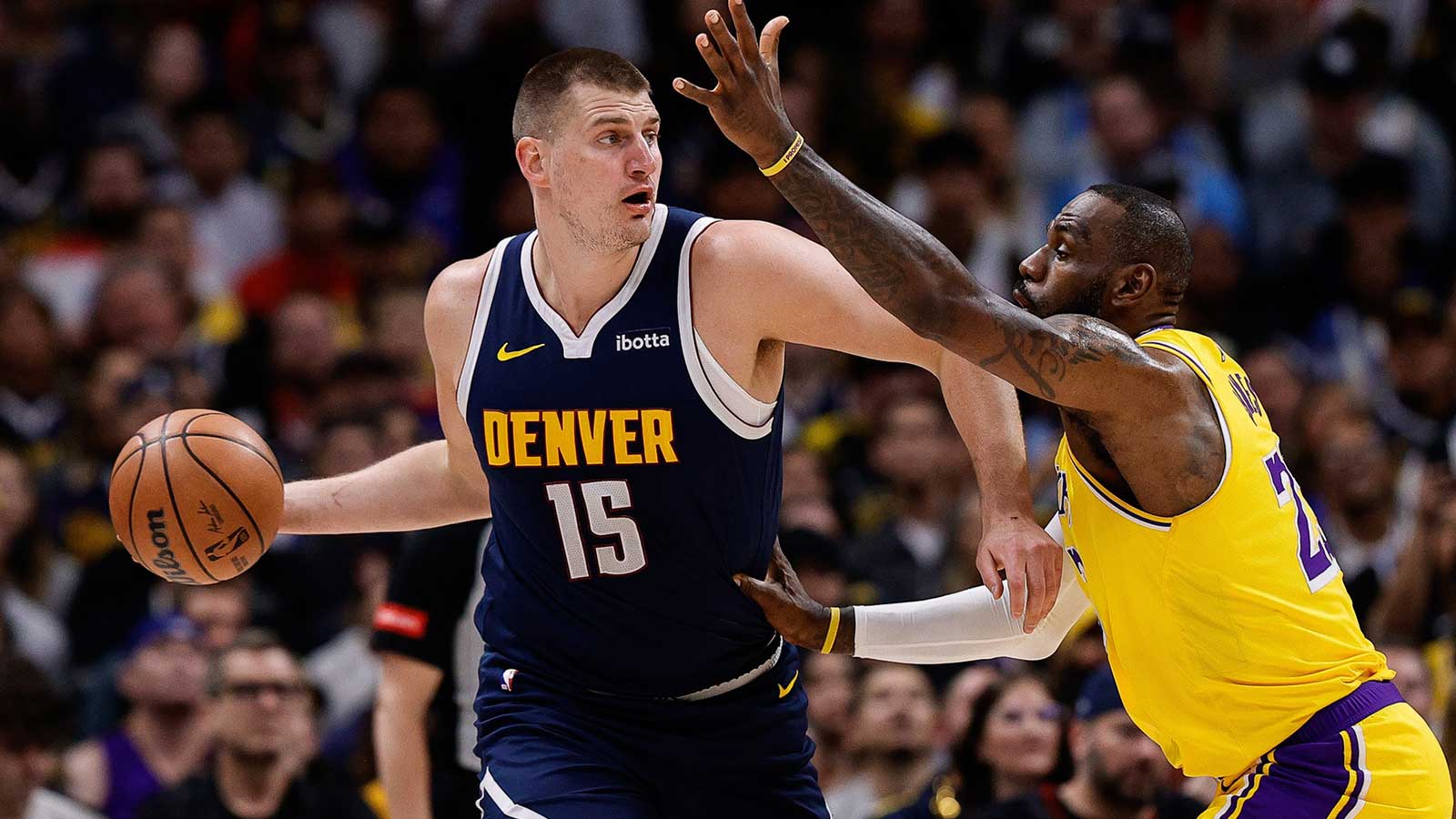 Denver Nuggets center Nikola Jokic (15) controls the ball under pressure from Los Angeles Lakers forward LeBron James (23) in the first quarter during game five of the first round for the 2024 NBA playoffs at Ball Arena.