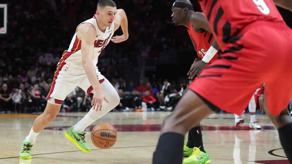 Miami Heat forward Nikola Jovic (5) drives to the basket as Portland Trail Blazers center Duop Reath (26) and forward Jerami Grant (9) defend in the first quarter at Kaseya Center.