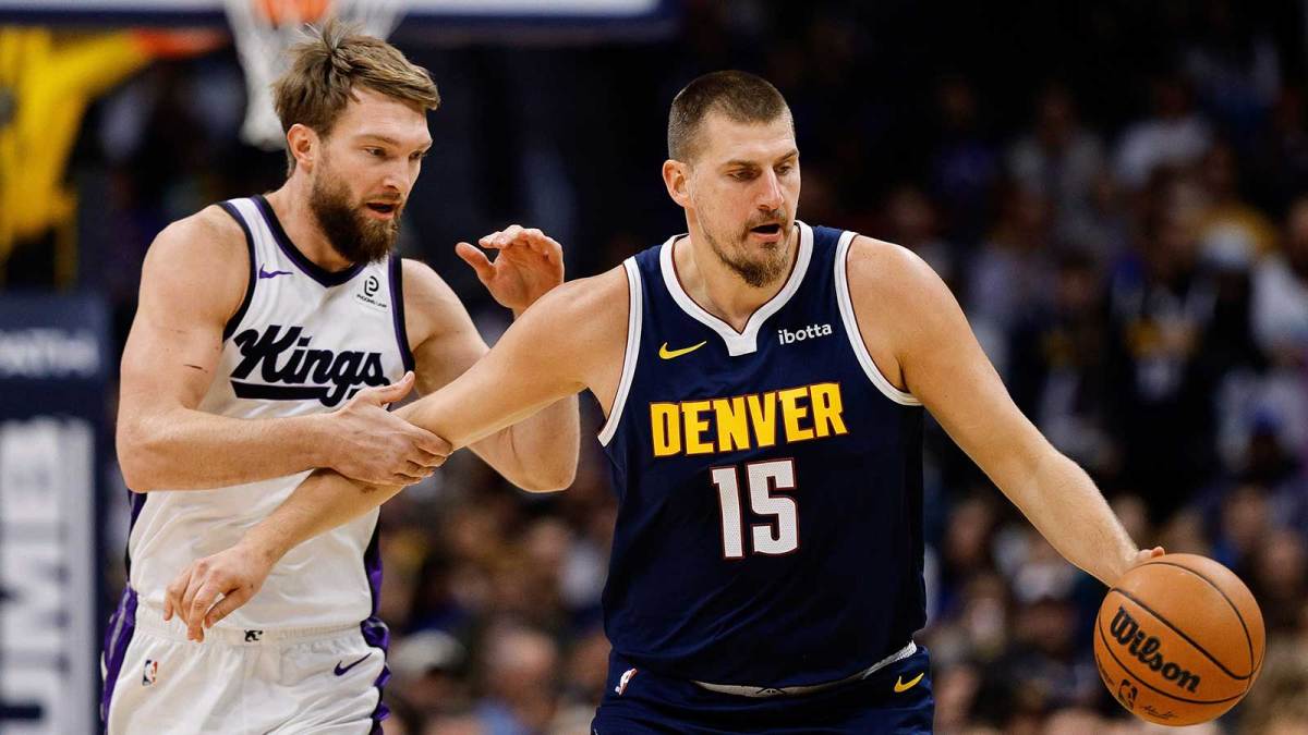 Denver Nuggets center Nikola Jokic (15) dribbles the ball up court as Sacramento Kings forward Domantas Sabonis (11) defends in the first quarter at Ball Arena.