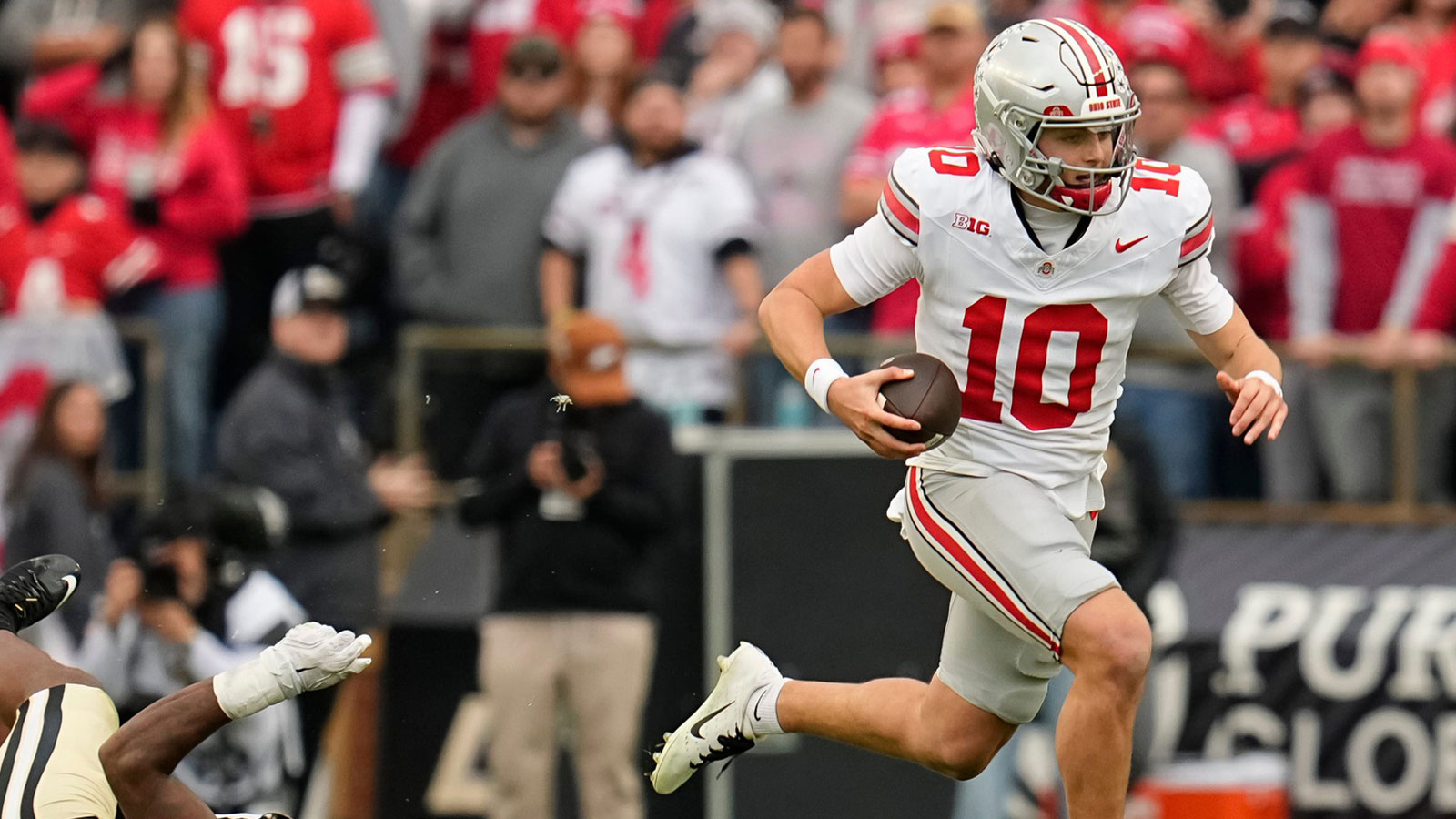 Ohio State Buckeyes quarterback Julian Sayin (10) runs past Purdue Boilermakers defensive lineman CJ Nunnally (91) during the NCAA football game at Ross-Ade Stadium in West Lafayette, Ind. on Nov. 8, 2025. Ohio State won 34-10.
