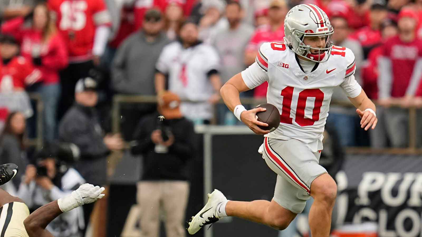 Ohio State Buckeyes quarterback Julian Sayin (10) runs past Purdue Boilermakers defensive lineman CJ Nunnally (91) during the NCAA football game at Ross-Ade Stadium in West Lafayette, Ind. on Nov. 8, 2025. Ohio State won 34-10