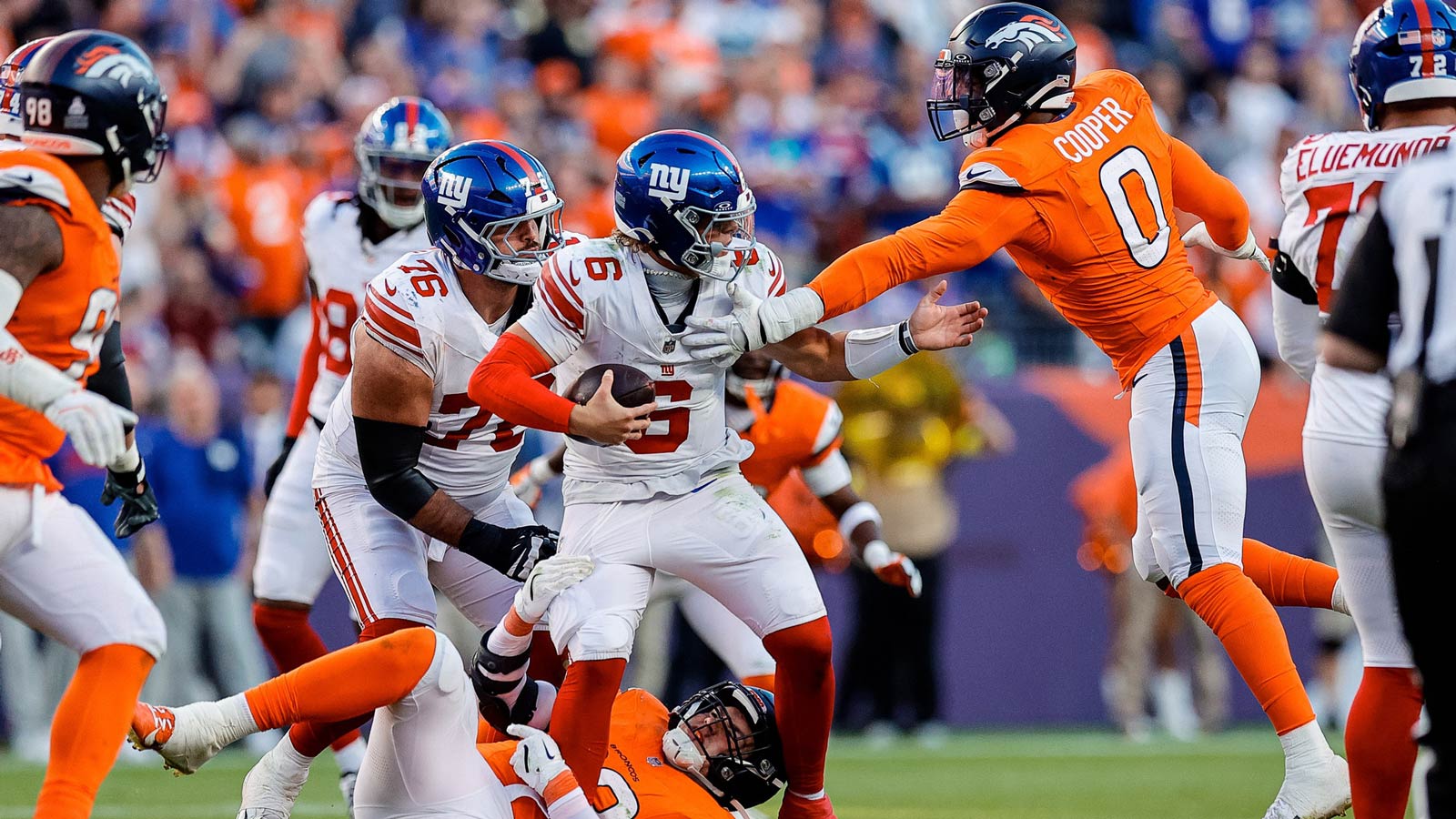 New York Giants quarterback Jaxson Dart (6) is sacked by Denver Broncos defensive end Zach Allen (99) and linebacker Jonathon Cooper (0) as guard Jon Runyan Jr. (76) defends in the fourth quarter at Empower Field at Mile High.