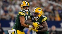 Green Bay Packers quarterback Jordan Love (10) hands the ball off to running back Josh Jacobs (8) during the game between the Dallas Cowboys and the Green Bay Packers at AT&T Stadium