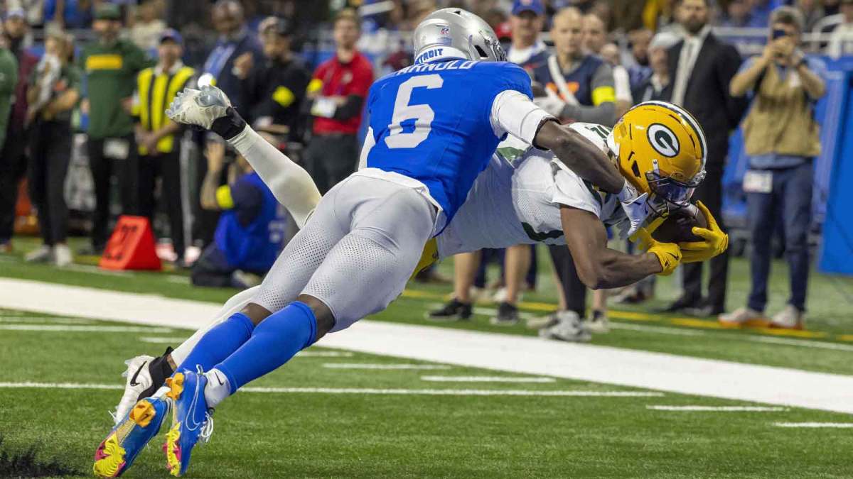 Green Bay Packers wide receiver Dontayvion Wicks (13) dives for the endzone for a touchdown against Detroit Lions cornerback Terrion Arnold (6) during the third quarter at Ford Field.