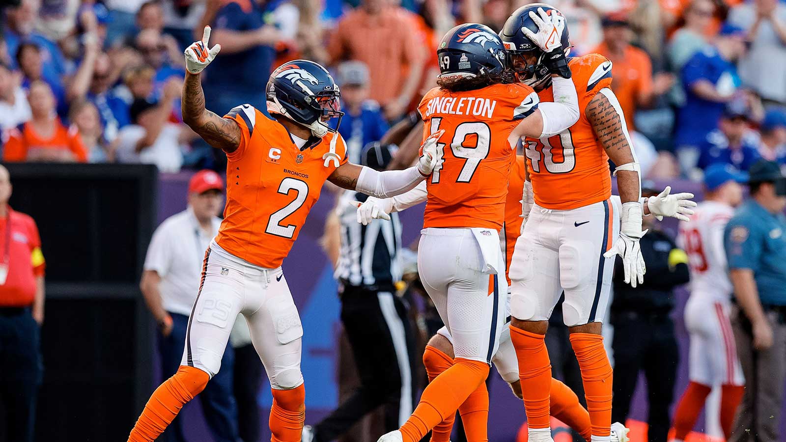 Denver Broncos linebacker Justin Strnad (40) celebrates his interception with linebacker Alex Singleton (49) and cornerback Pat Surtain II (2) in the fourth quarter against the New York Giants at Empower Field at Mile High.