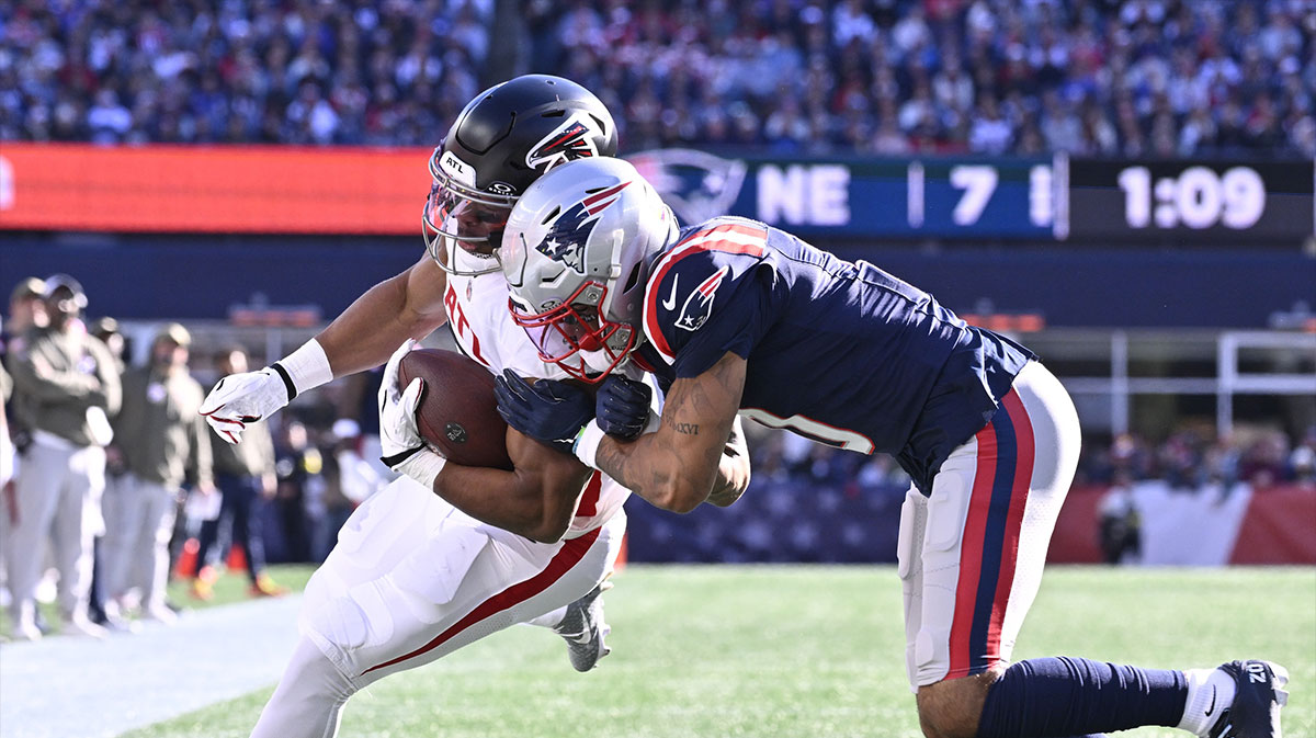 Atlanta Falcons offensive tackle Jake Matthews (70) is knocked out of bounds by New England Patriots cornerback Christian Gonzalez (0) during the first half at Gillette Stadium.