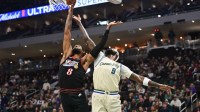 Milwaukee Bucks forward Bobby Portis (9) and Philadelphia 76ers forward Paul George (8) battle for a rebound in the first quarter at Fiserv Forum.