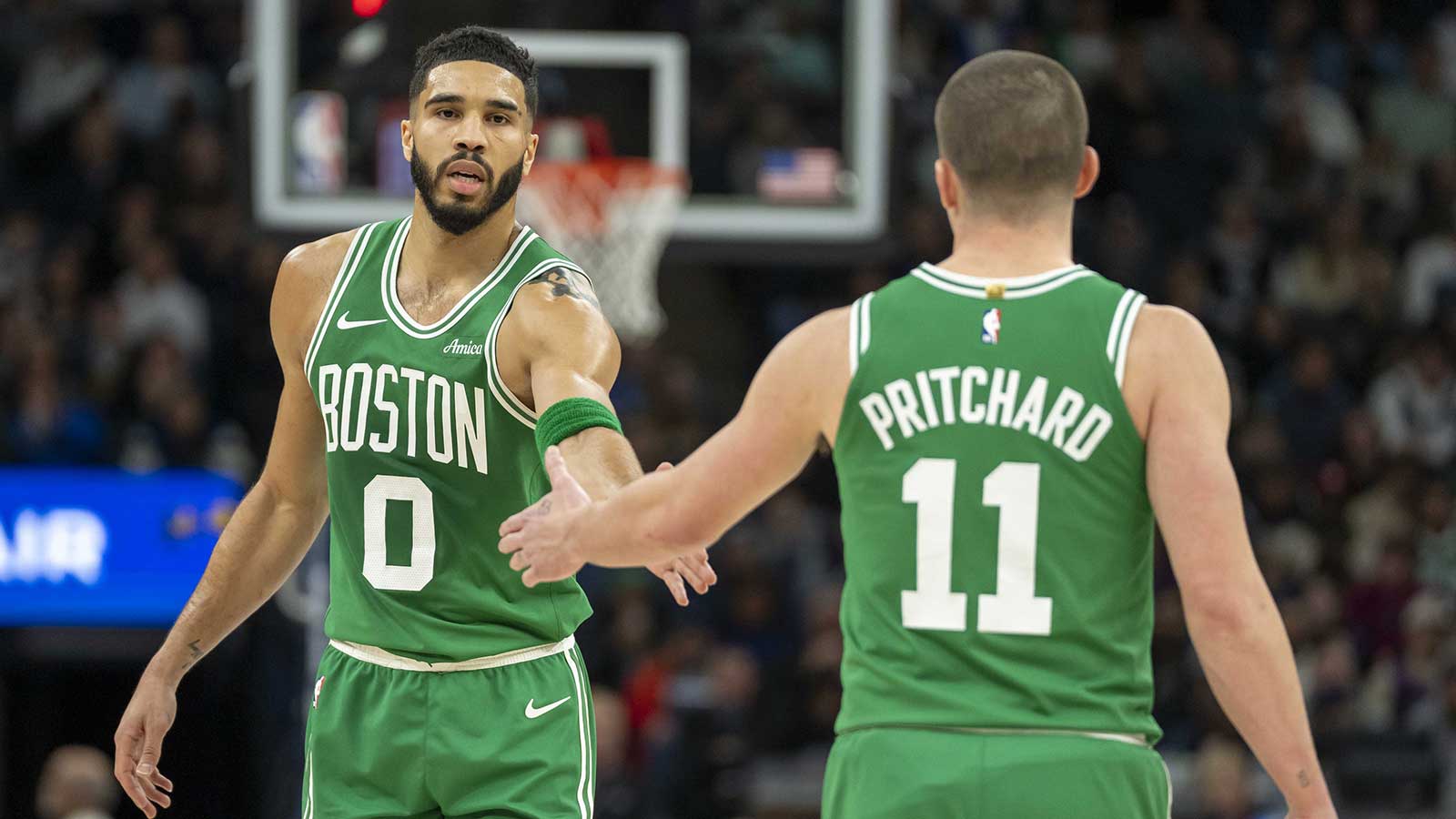 Boston Celtics forward Jayson Tatum (0) celebrates with guard Payton Pritchard (11) after making a shot against the Minnesota Timberwolves in the first half at Target Center.