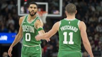 Boston Celtics forward Jayson Tatum (0) celebrates with guard Payton Pritchard (11) after making a shot against the Minnesota Timberwolves in the first half at Target Center.