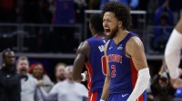 Pistons guard Cade Cunningham (2) celebrates in overtime against the Washington Wizards at Little Caesars Arena with the Cavs logo in the background