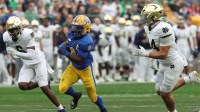 Pittsburgh Panthers running back Desmond Reid (0) runs the ball as Notre Dame Fighting Irish cornerback Christian Gray (6) and linebacker Drayk Bowen (34) chase during the third quarter at Acrisure Stadium.