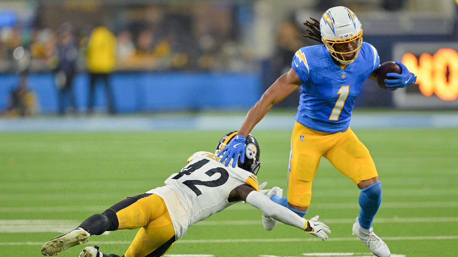 Los Angeles Chargers wide receiver Quentin Johnston (1) carries the ball defended by Pittsburgh Steelers cornerback James Pierre (42) during the second quarter of the game at SoFi Stadium.