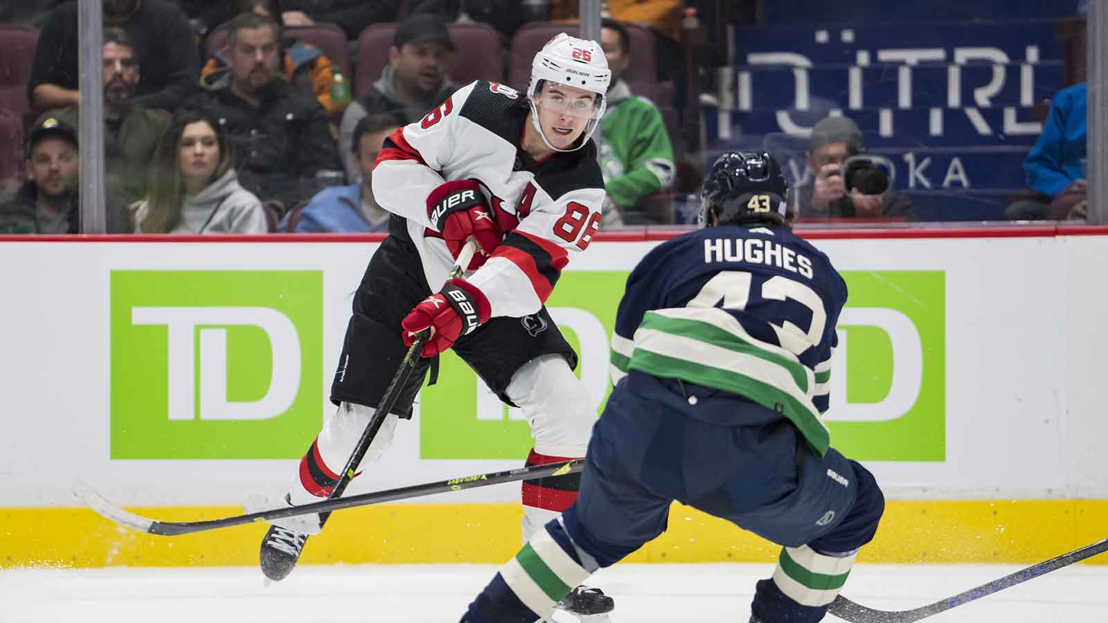 New Jersey Devils forward Jack Hughes (86) passes around Vancouver Canucks defenseman Quinn Hughes (43) in the second period at Rogers Arena. 