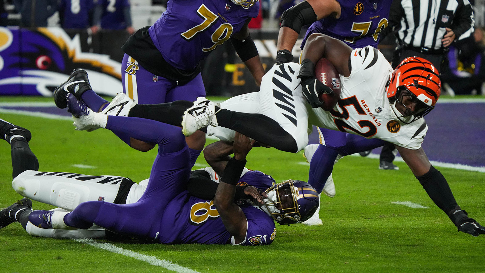 Bengals Joseph Ossai (58) helps take down Ravens Lamar Jackson (8)for Bengals Cedric Johnson (52) to gain possesion of the ball during their game against the Ravens at M&T Bank Stadium on Thanksgiving Thursday November 27, 2025.