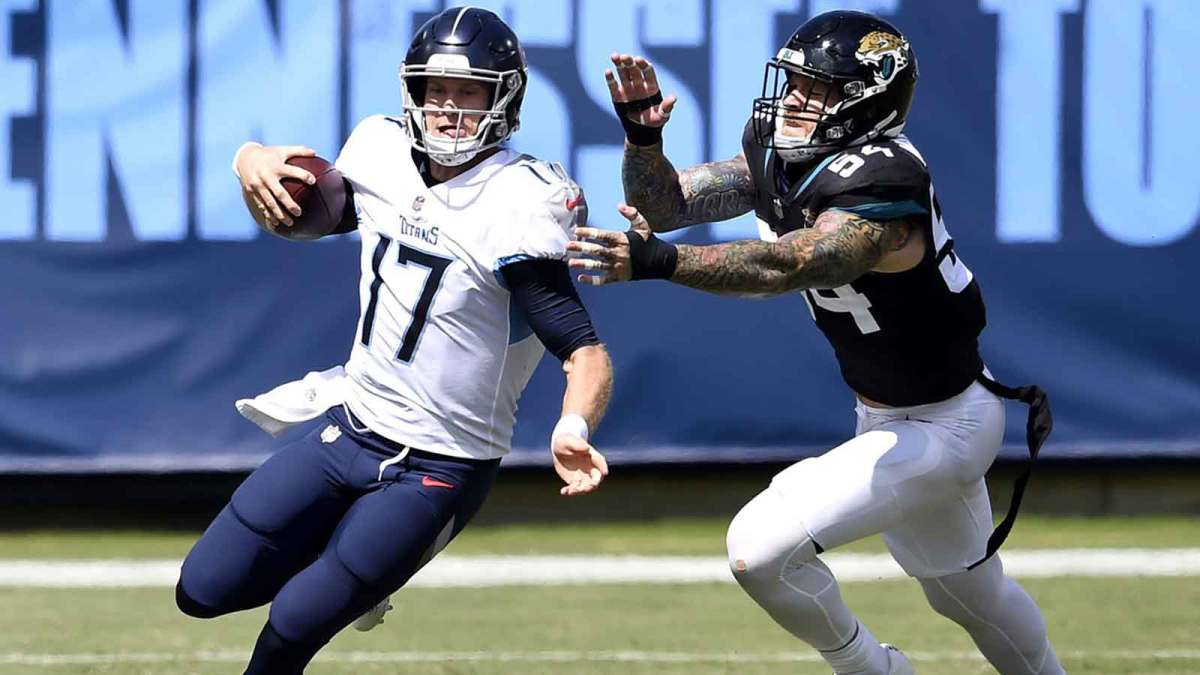 Tennessee Titans quarterback Ryan Tannehill (17) scrambles up the field away from Jacksonville Jaguars defensive end Cassius Marsh (54) at Nissan Stadium in Nashville on Sept. 20, 2020. The Titans won their home opener 33-30.