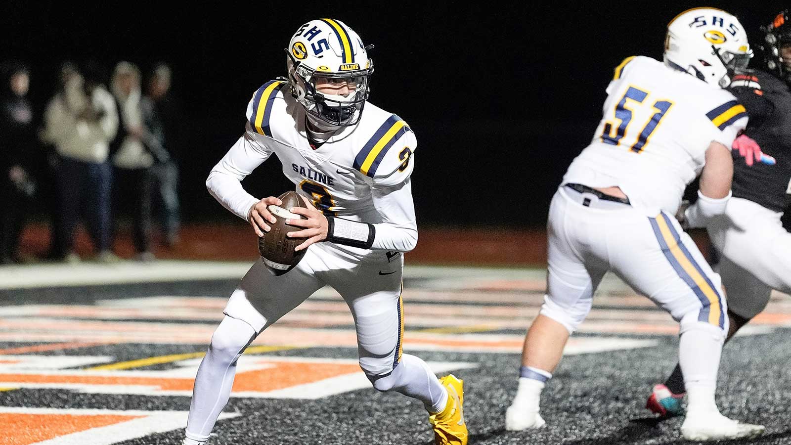 Saline quarterback Tommy Carr looks to pass against Belleville during the first half of district final at Belleville High School in Belleville on Friday, Nov. 8, 2024.
